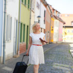 Eine Frau läuft mit einem Rollkoffer durch die Straßen