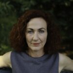 Eine Frau schaut gerissen in die Kamera
