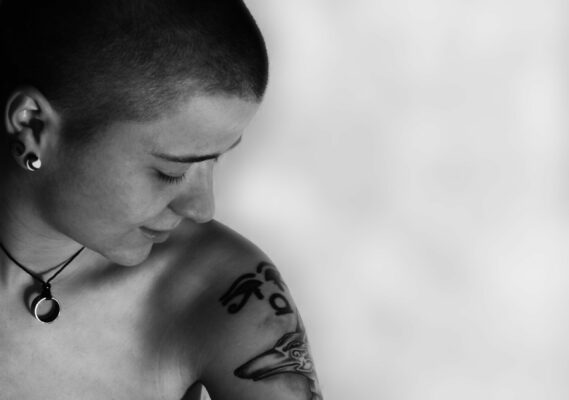 eine Person schaut sich eine Tattoo auf ihrer Schulter an